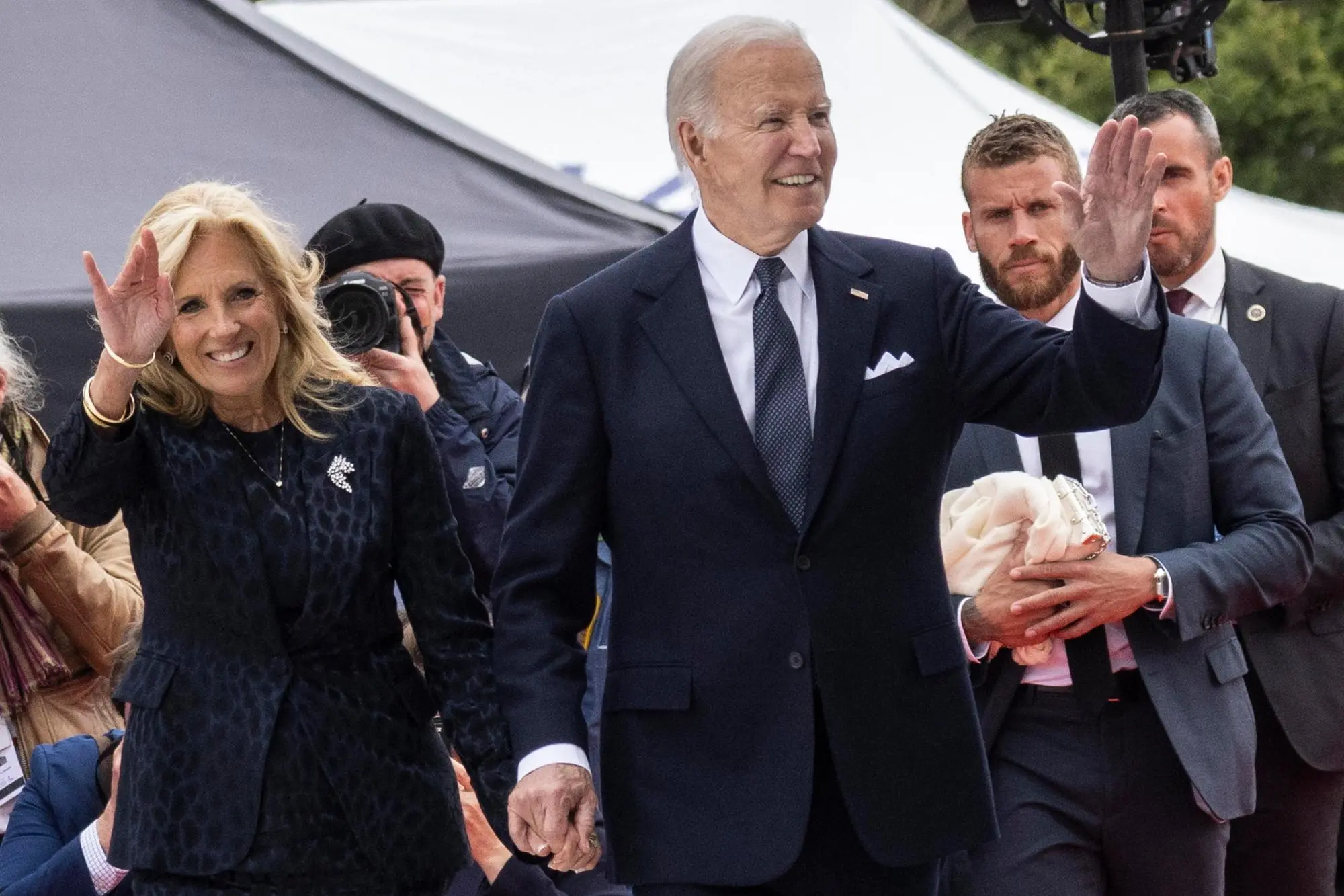 epa11393993 US President Joe Biden (R) and his wife Jill Biden greet the audience as they arrive to attend the commemorative ceremony with dozens of heads of States and more than 200 veterans for the 80th anniversary of D-Day landings in Normandy at Omaha Beach, Saint-Laurent-sur-Mer, France, 06 June 2024. More than 160,000 Western allied troops landed on beaches in Normandy on 06 June 1944 launching the liberation of Western Europe from Nazi occupation during World War II. EPA/ANDRE PAIN