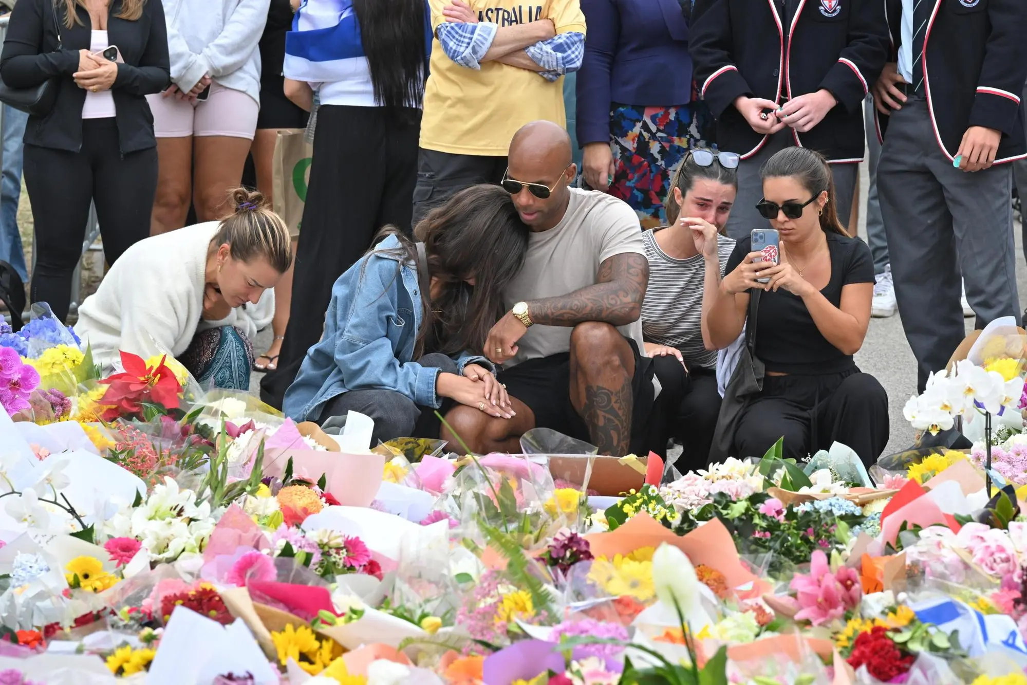 Fiori e lacrime dopo la strage a Bondi Beach (foto Ansa/Epa)