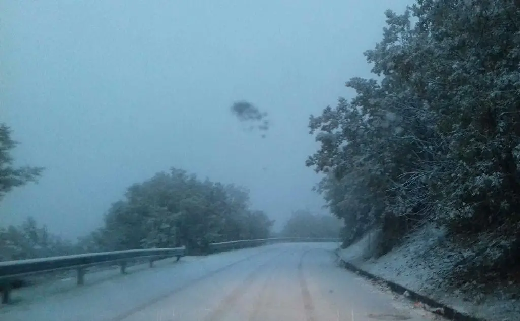 La neve cade copiosa sul manto stradale