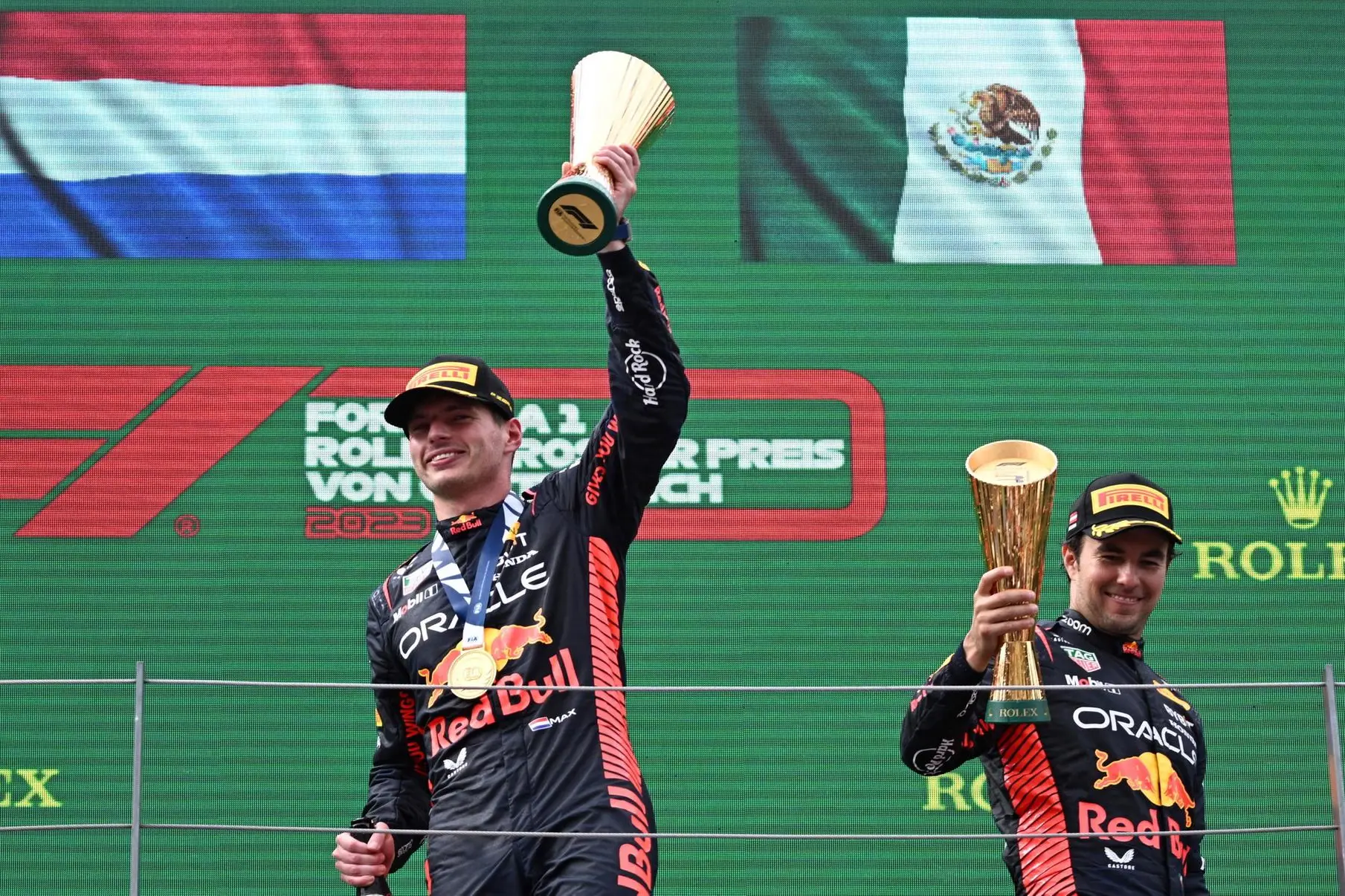 epa10722542 First placed Dutch Formula One driver Max Verstappen (L) of Red Bull Racing and third placed Mexican teammate Sergio Perez (R) celebrate with the trophies on the podium after the Formula 1 Austrian Grand Prix at the Red Bull Ring race track in Spielberg, Austria, 02 July 2023. EPA/CHRISTIAN BRUNA