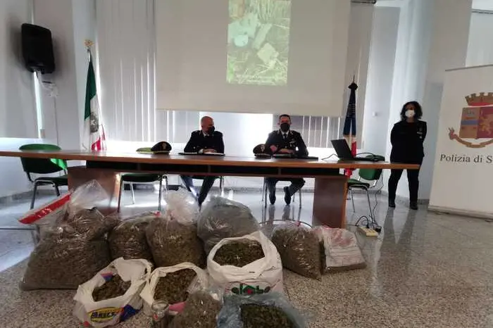 Gli inquirenti con la droga sequestrata (Ansa)