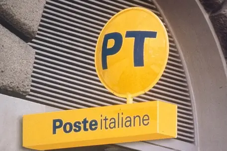 L'insegna di Poste italiane all'ingresso di un ufficio (Ansa)