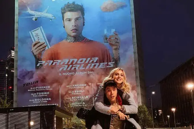 Fedez e Chiara Ferragni davanti al gigantesco manifesto del nuovo album del rapper (foto da Instagram @Fedez)