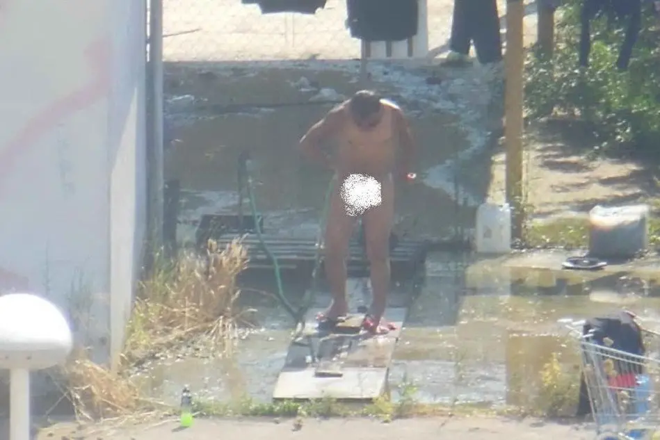 Un uomo fa la doccia all'aperto