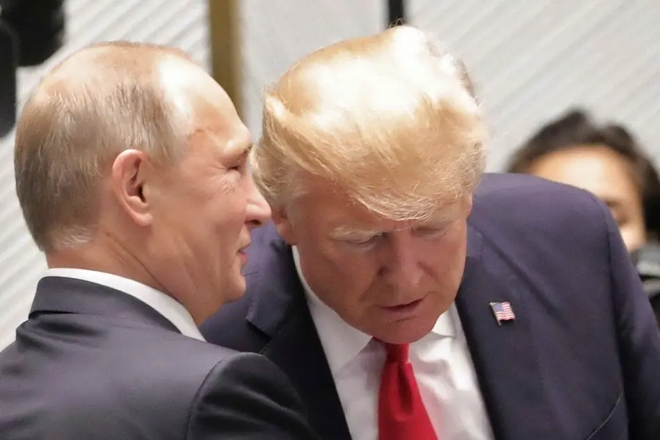 Vladimir Purtin parla all'orecchio a Donald Trump (foto Sputnik)