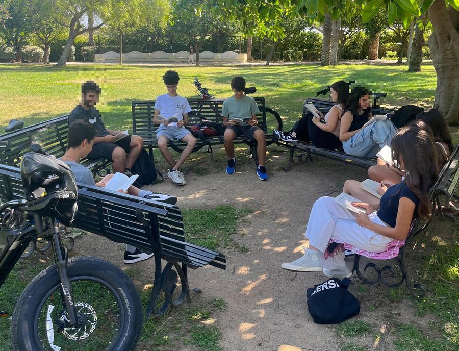 Al parco d’estate: nove ragazzi con un libro in mano