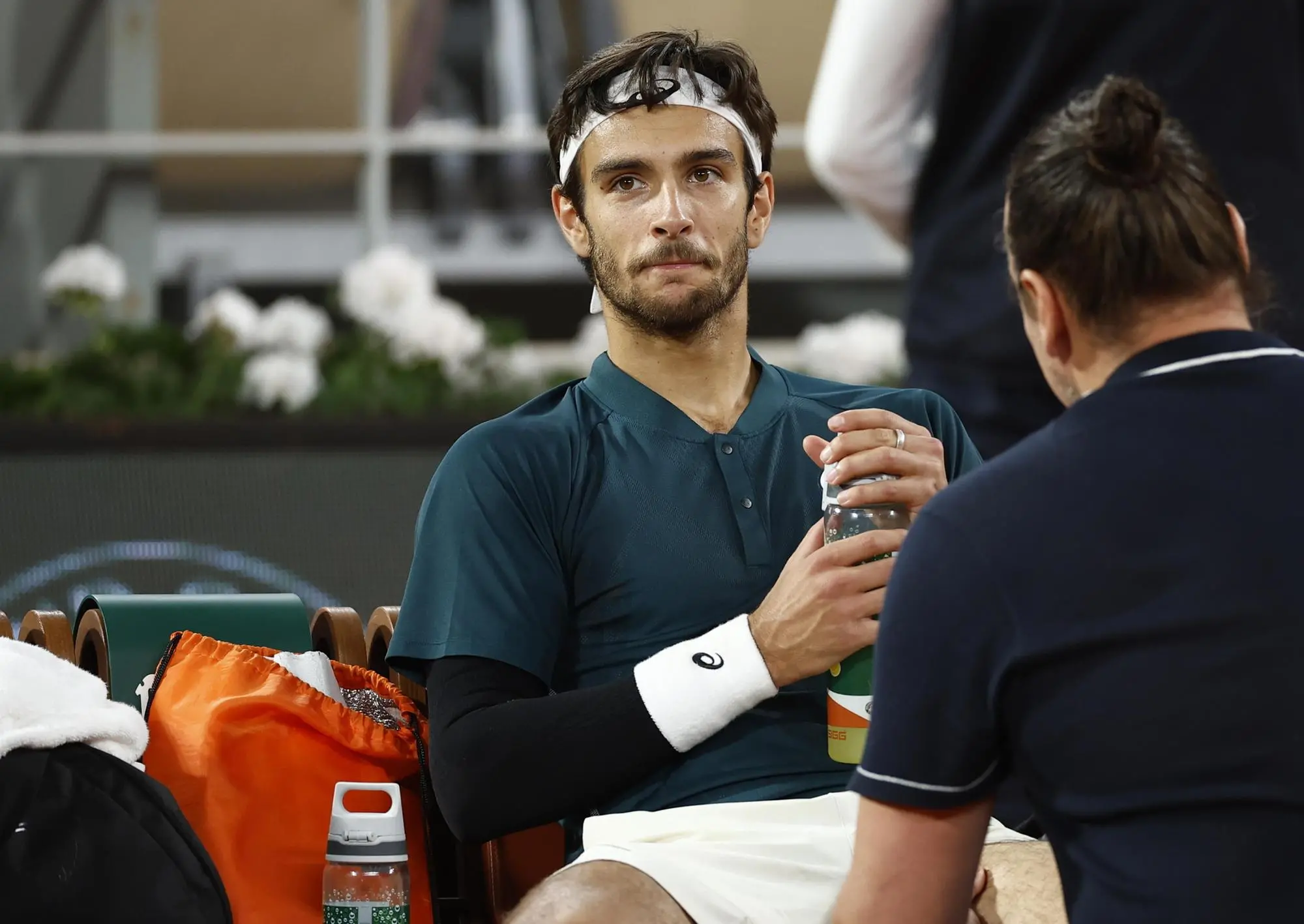 epa12160385 Lorenzo Musetti of Italy receives medical attention during his Men's Singles semi-finals match against Carlos Alcaraz of Spain at the French Open Grand Slam tennis tournament at Roland Garros in Paris, France, 06 June 2025. EPA/YOAN VALAT