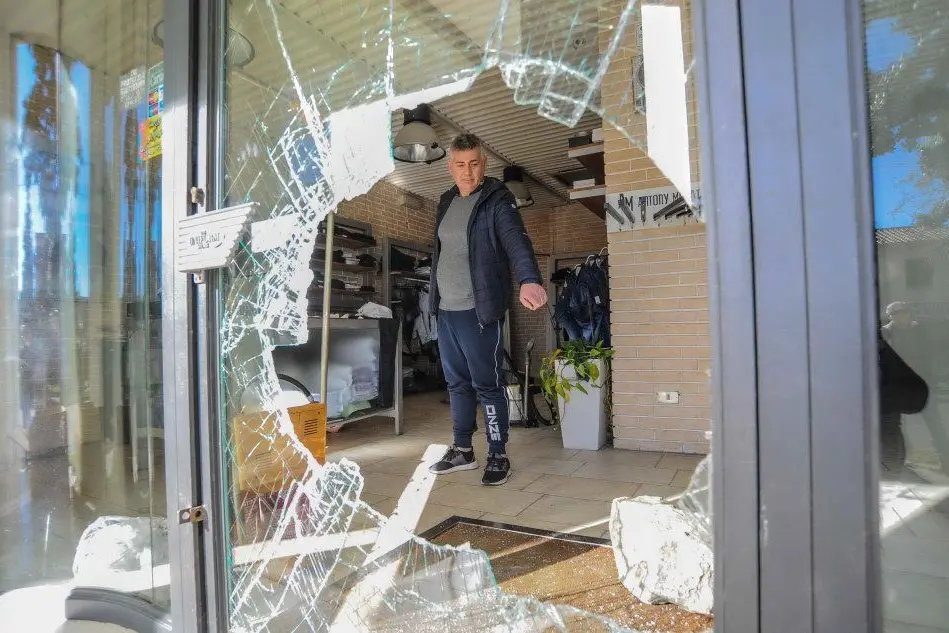 Il titolare del negozio Pereyra, Salvatore Bove, davanti alla vetrata sfondata dai ladri (Foto A.Cucca