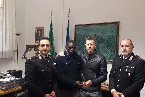 Il senegalese e l'imprenditore tra i due carabinieri (Ansa)