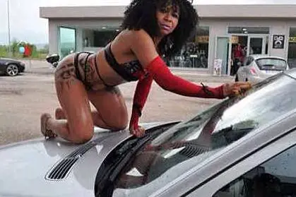 Un momento del sexy car wash: una donna che indossa abiti succinti sostituisce l'operaio in tuta preposto alla pulizia della macchina