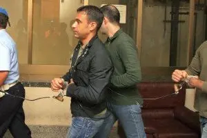 I tre banditi scortati in catene al palazzo di Giustizia