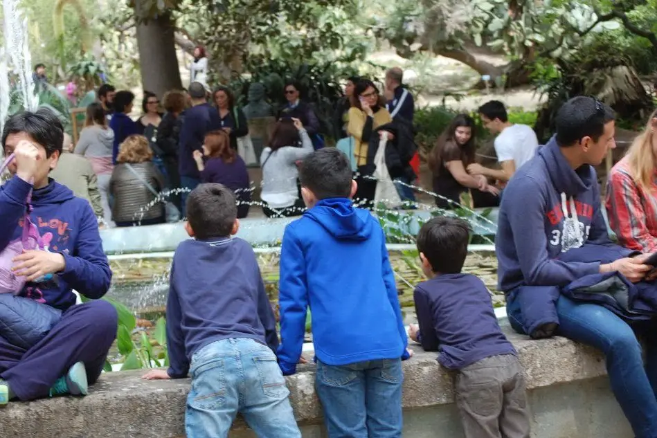 Un gruppo di bambini e visitatori attorno alla vasca centrale dell'Orto Botanico