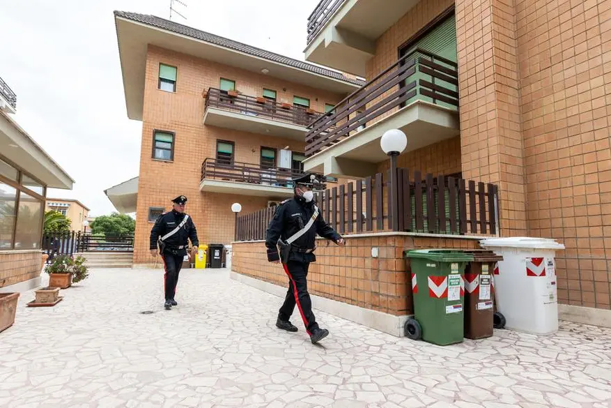 I rilievi delle forze dell'ordine all'esterno dell'appartamento (Ansa - Antimiani)