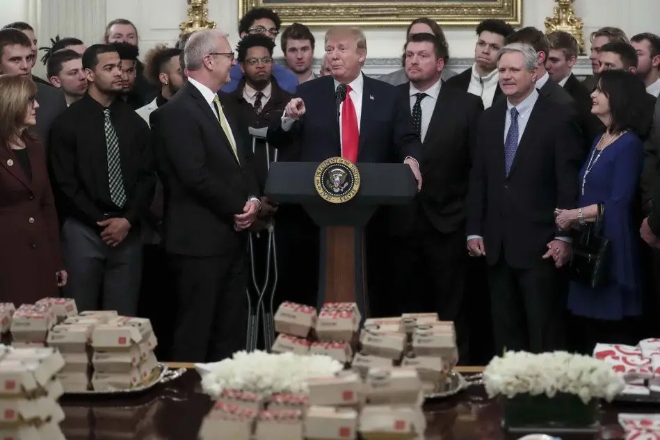 Trump e i suoi ospiti davanti alla tavola imbandita di hamburger (Ansa)