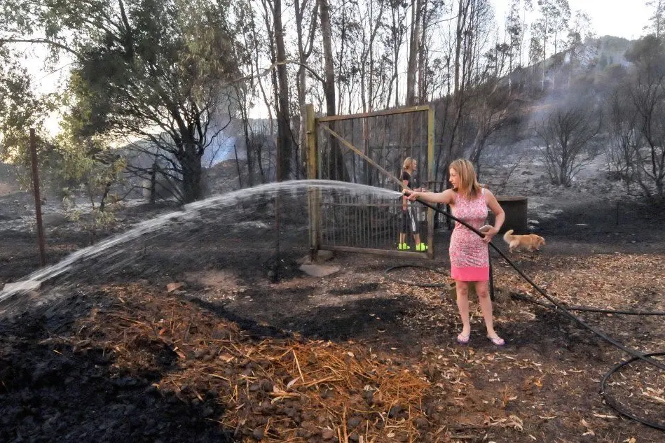 Una donna in un'azienda distrutta dalle fiamme