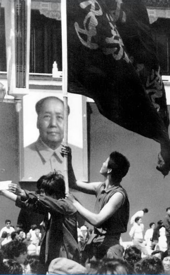Studenti davanti all'immagine di Mao Zedong (Ansa)