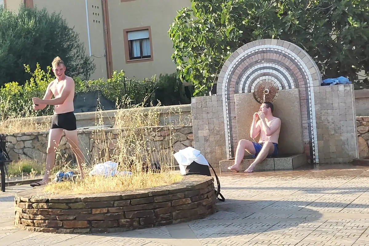 I turisti che fanno la doccia nella fontana a Olbia