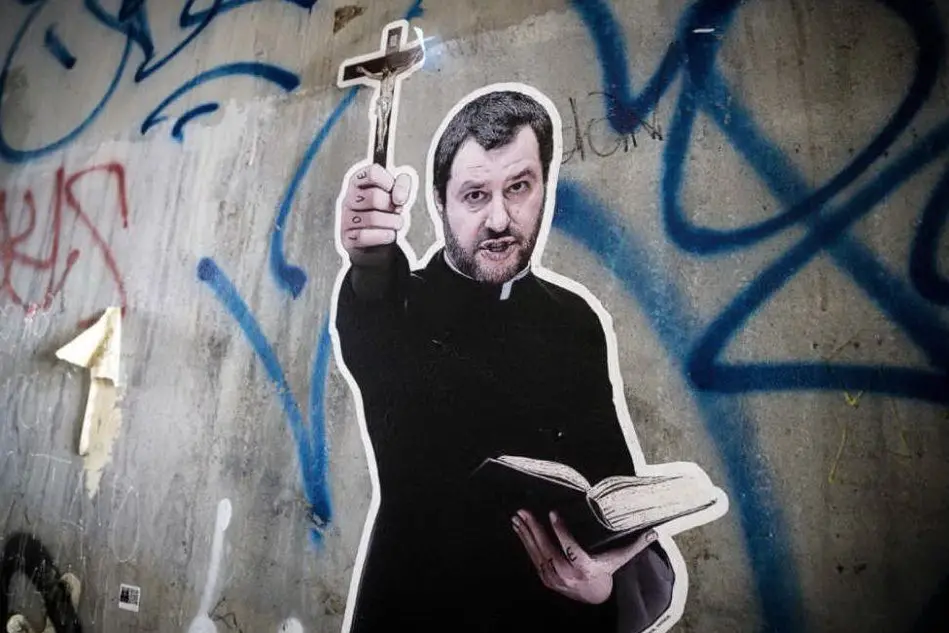Un'immagine di Salvini, crocifisso e testi sacri in mano, opera di uno street artist a Roma (Ansa)