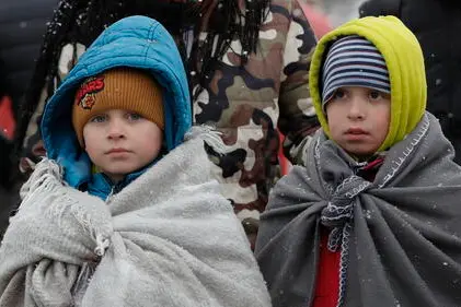 Two Ukrainian children, wearing blankets on their shoulders, pass through the border crossing of Siret, northern Romania, 07 March 2022. ANSA/ROBERT GHEMENT