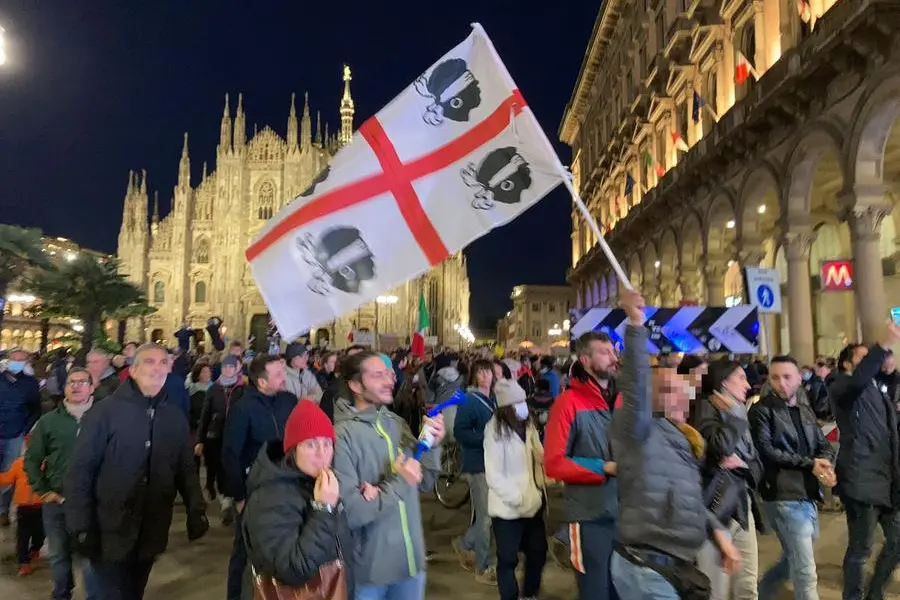 Un manifestante No Green Pass a Milano con la bandiera dei 4 Mori (Foto L'Unione Sarda.it)