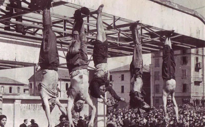 Il cadavere di Mussolini assieme a quelli di Claretta Petacci e di altri gerarchi fascisti fucilati esposti a testa in giù in Piazzale Loreto, a Milano