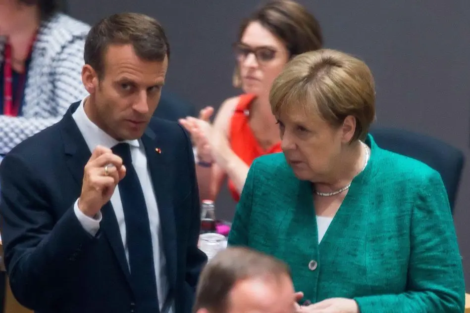Accordo trovato al summit di Bruxelles sui migranti (a sinistra il presidente francese Macron, a destra la cancelliera tedesca Angela Merkel)