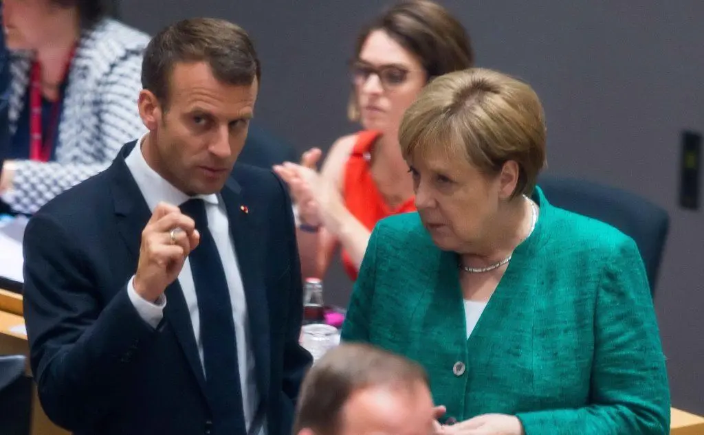 Accordo trovato al summit di Bruxelles sui migranti (a sinistra il presidente francese Macron, a destra la cancelliera tedesca Angela Merkel)