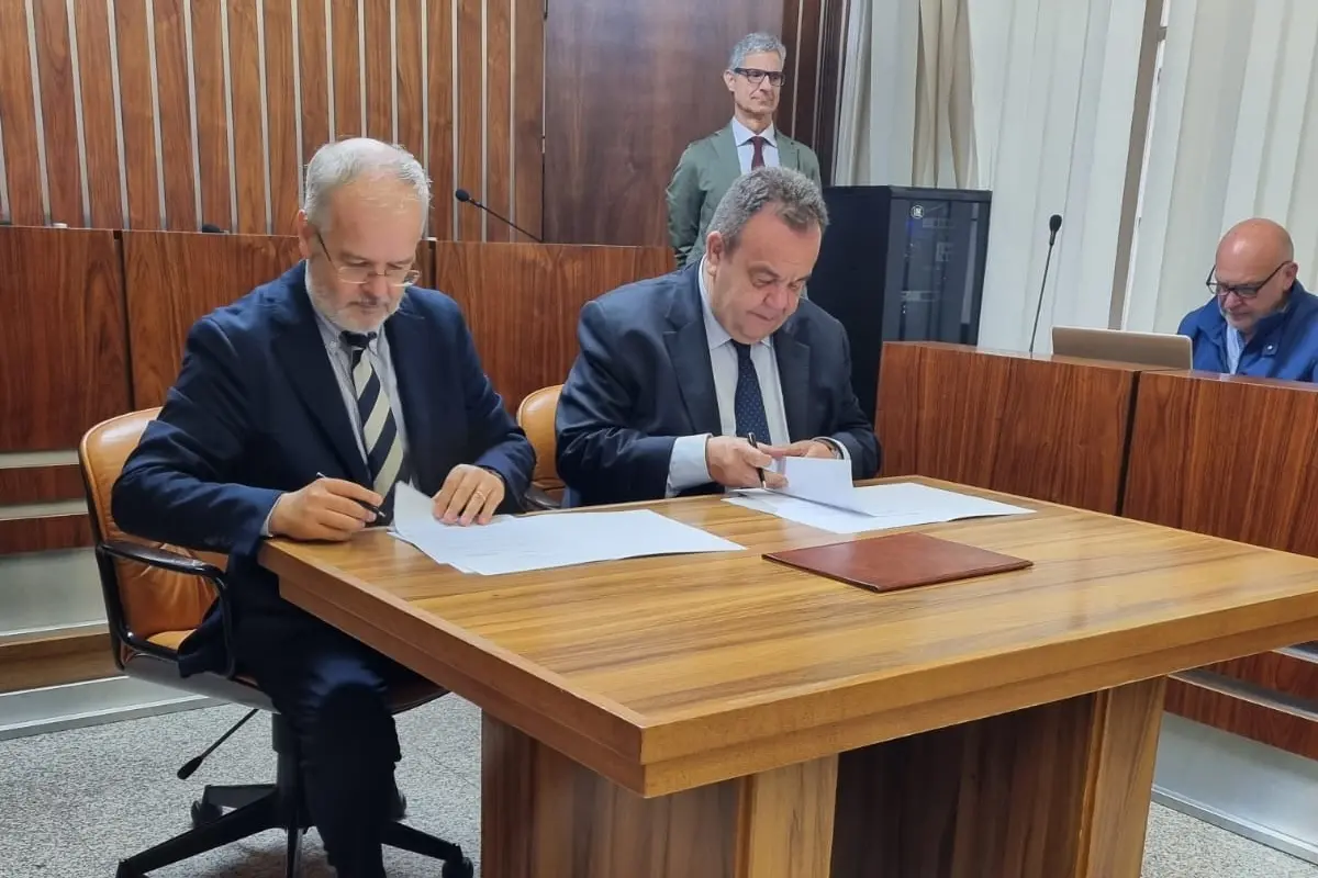 La firma dell'accordo tra il presidente del Corecom Sergio Nuvoli, a sinistra, e il rettore Gavino Mariotti, a destra (L'Unione Sarda)