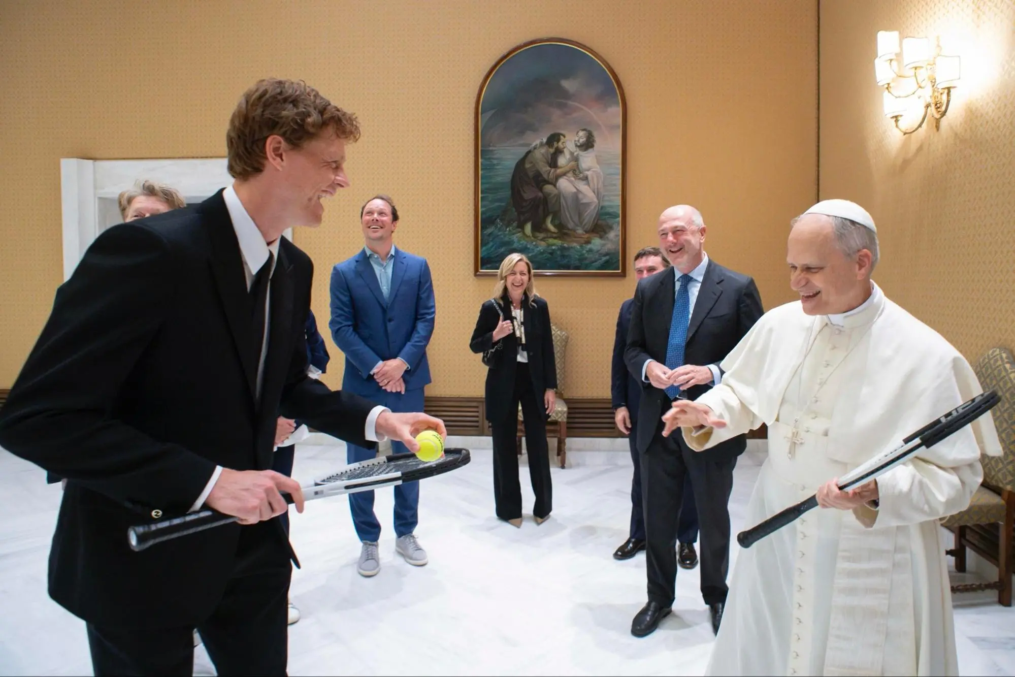 A photo distributed by Vatican Media shows Italian tennis player Jannik Sinner giving a tennis racket to the Pope. The champion had his own and a ball and asked Leone: "Do you want to play?" The Pope showed him the room with lamps and other furniture and laughingly replied: "Let's leave it, it's better not to here". Leone also added laughing: "At Wimbledon they would let me...", meaning that on the famous British court they would let him play with the new racket. Rome, 14 May 2025. ANSA / VATICAN MEDIA HANDOUT