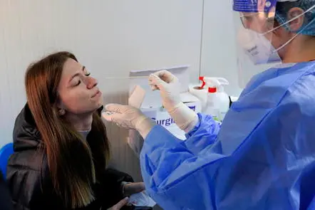 epa09708132 A hospital staff wearing fully protective suit (R) prepares to take samples for RT-PCR test from a suspected woman inside a newly installed container for testing infected patients, at the National Institute of Pneumology 'Marius Nasta', in Bucharest, Romania, 25 January 2022. Authorities have decided that from 24 January, all those who have symptoms or believe that they have come into contact with infected people will be able to be tested in new container testing sections opened in all available hospitals in Bucharest, to help managing the large number of infections generated by the fifth wave of Covid-19. Bucharest residents who have specific symptoms of COVID can go to be tested, free of charge, in the newly opened testing centers only after registering in the data base of Public Health Directorate (DSV) of Bucharest, through their Call Center system, or through the online platform. On January 25, 19,685 new cases of people infected with SARS - CoV2 and 44 deaths were officially reported. EPA/ROBERT GHEMENT