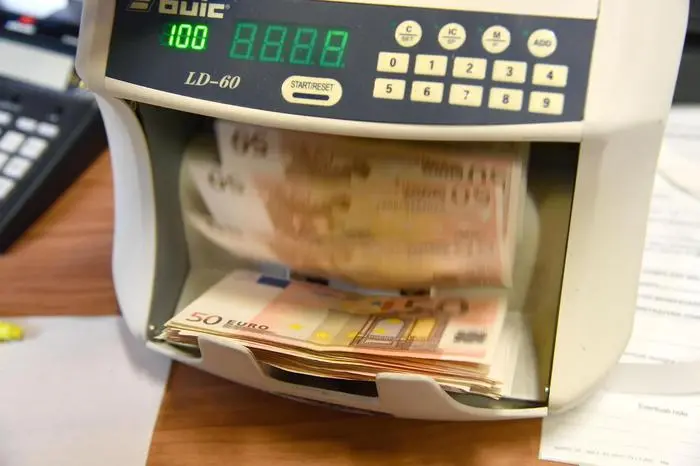 Alcune banconote da 50 Euro in un contasoldi bancario.