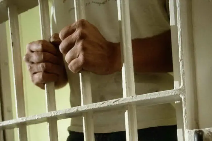 Un detenuto rinchiuso in una cella