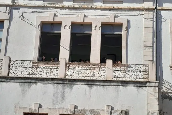 Alunni alle finestre della scuola De Amicis (foto Ansa)