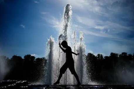 epaselect epa10105954 A boy walks near a fountain during hot temperatures, at Lustgarten park in Berlin, Germany, 04 August 2022. The German Weather Service (DWD) expects the heat wave to peak in the coming days, highs between 34 and 38 degrees Celsius are predicted in large parts of Germany. EPA/CLEMENS BILAN