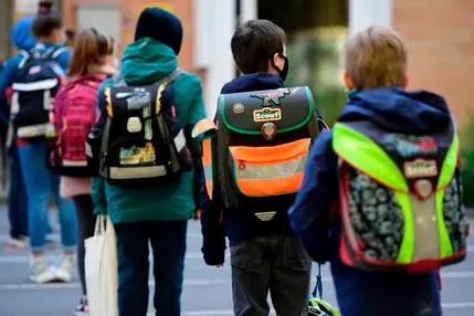 Children respect social distancing rules as they line up to enter the Petri primary school in Dortmund, western Germany, on May 7, 2020, as the school reopens for some pupils following lockdown due to the new coronavirus Covid-19 pandemic. - The primary schools in the western federal state of North Rhine-Westphalia reopened as planned for fourth-graders. (Photo by Ina FASSBENDER / AFP)