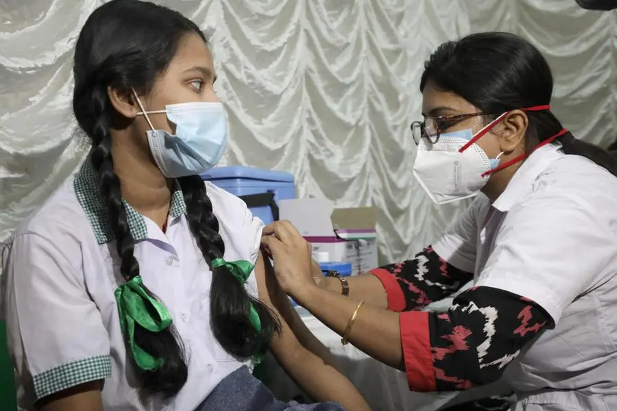 Vaccinazione a una studentessa (Ansa)