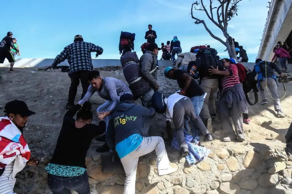 Migranti cercano di superare il confine tra Messico e Usa (Ansa)