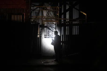 epaselect epa09269329 A man uses his cell phone's flashlight to illuminate the entrance to his home, during a blackout in Caracas, Venezuela, 13 June 2021. An electrical failure has left a large part of Caracas and at least two states closest to the Venezuelan capital without power. EPA/RAYNER PENA