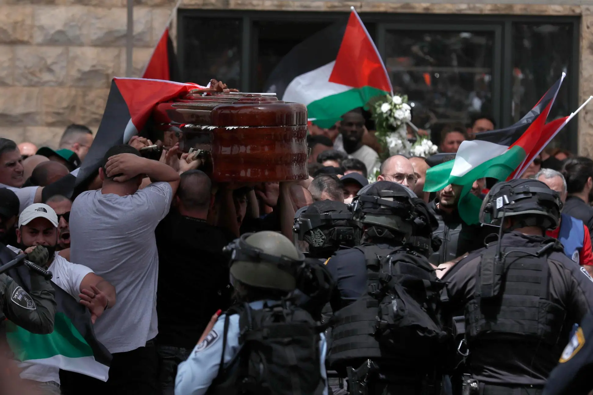 epaselect epa09944328 Mourners carry the coffin of slain American-Palestinian journalist Shireen Abu Akleh outside St. Joseph Hospital, ahead of a funeral procession in the Old City of Jerusalem, 13 May 2022. Al Jazeera journalist Shireen Abu Akleh was killed on 11 May 2022 during a raid by Israeli forces in the West Bank town of Jenin. EPA/ATEF SAFADI