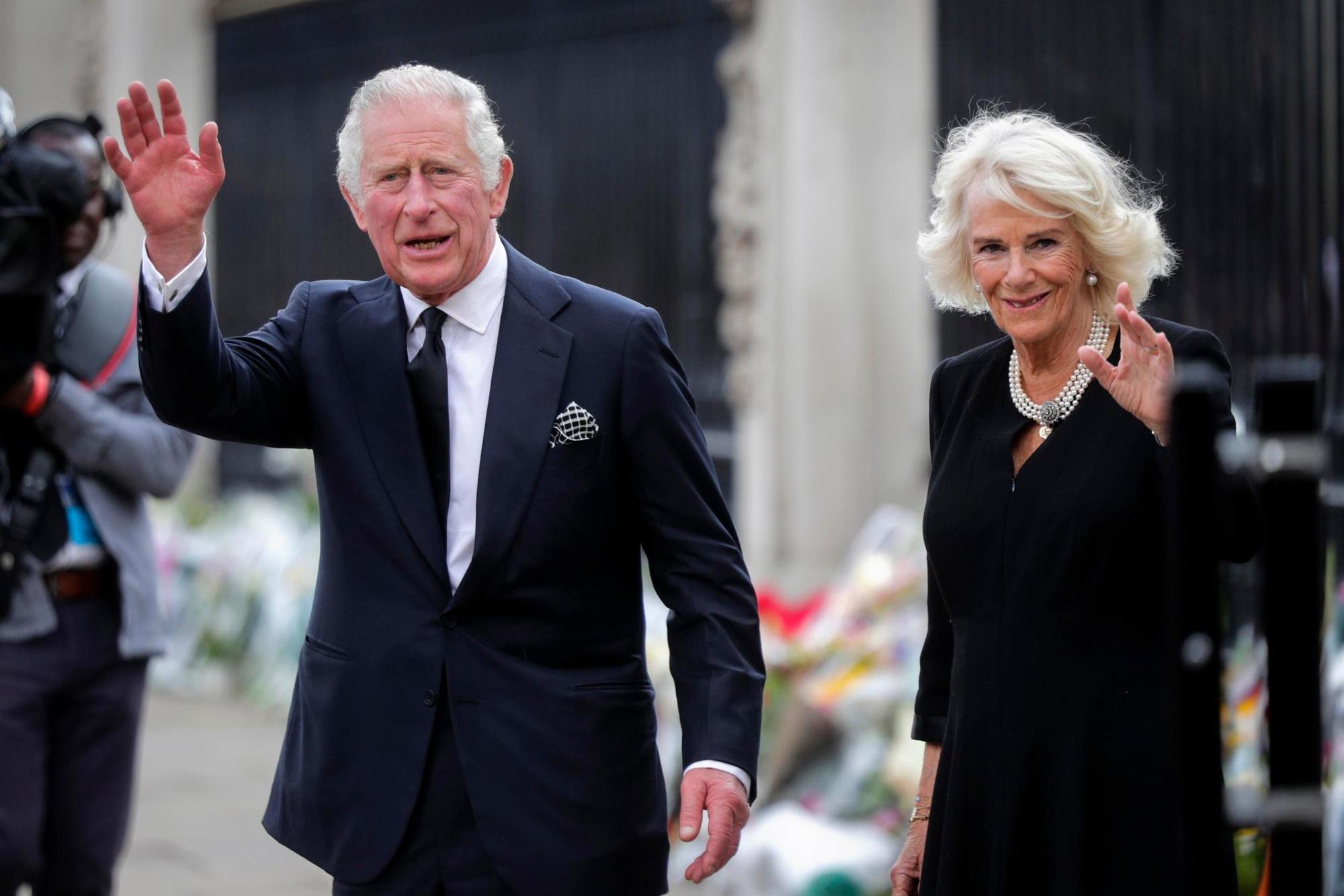 epaselect epa10173573 Britain's King Charles III (L) and Camilla, the Queen Consort, look at the floral tributes left outside Buckingham Palace in London, Britain, 09 September 2022. Britain's Queen Elizabeth II died at her Scottish estate, Balmoral Castle, on 08 September 2022. The Prince of Wales became King after the death of his mother and will be known as King Charles III. EPA/OLIVIER HOSLET