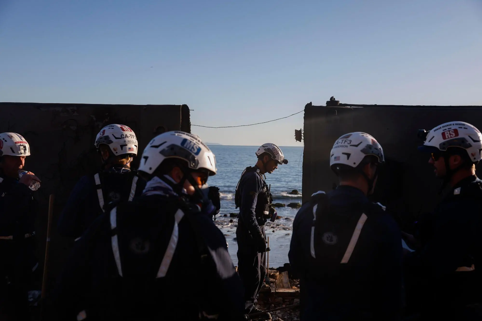 Le squadre di ricerca e salvataggio ispezionano il sito di una casa distrutta dal fuoco a Malibu, California (Ansa)