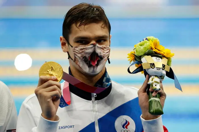 epaselect epa09378123 Gold medalist Evgeny Rylov of the Russian Olympic Committee who set an Olympic record shows his medal at the Men's 200m Backstroke Final medal ceremony at the Swimming event of the Tokyo 2020 Olympic Games at the Tokyo Aquatics Centre in Tokyo, Japan, 30 July 2021. EPA/HOW HWEE YOUNG
