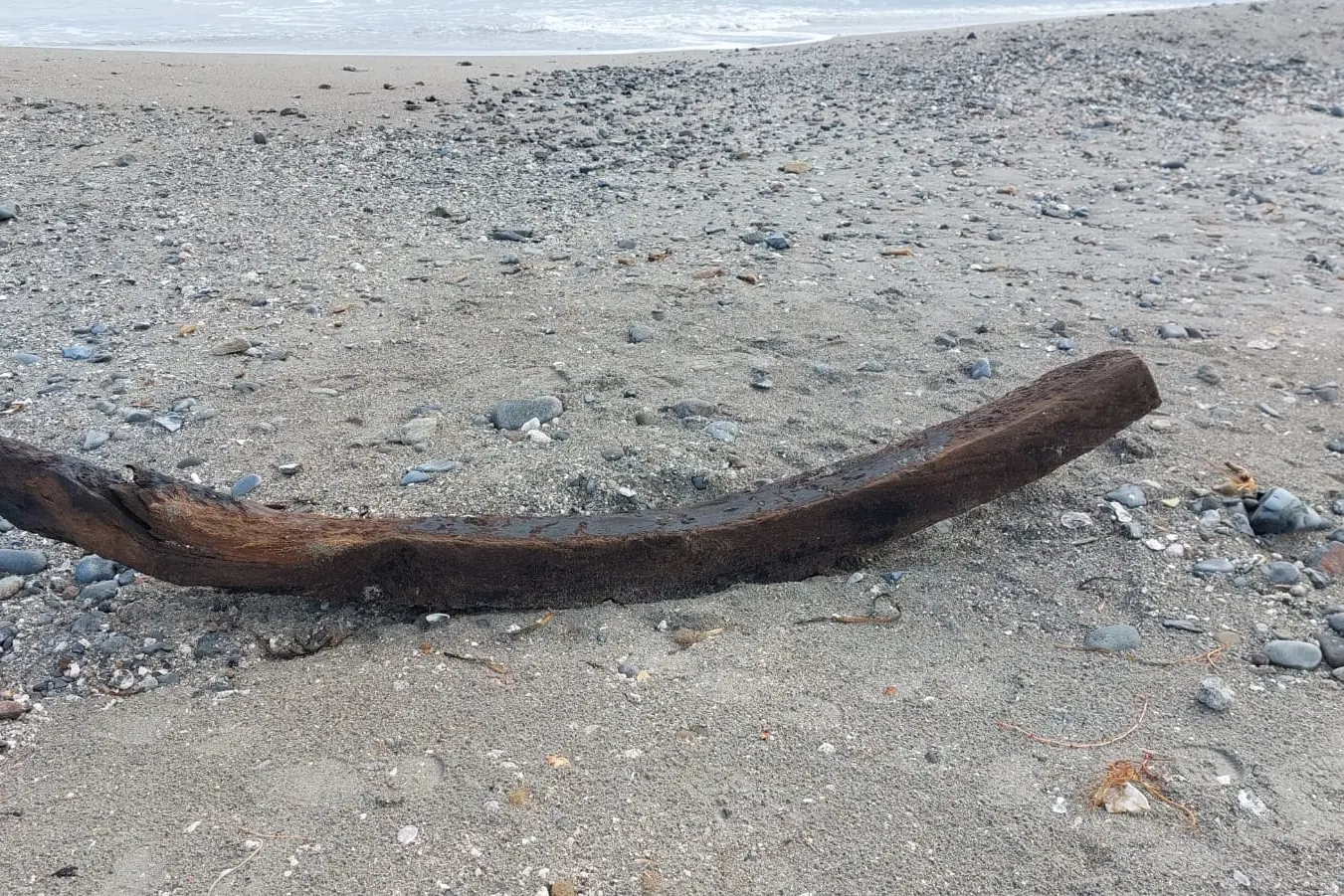 Un pezzo del relitto sulla spiaggia del Poetto