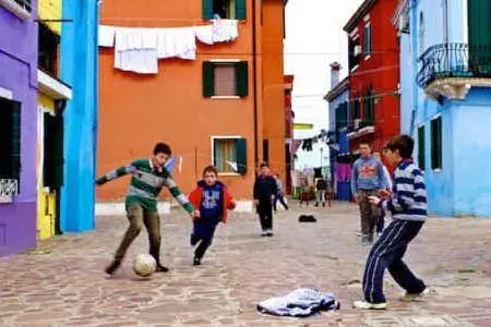 Ragazzini giocano a calcio per strada
