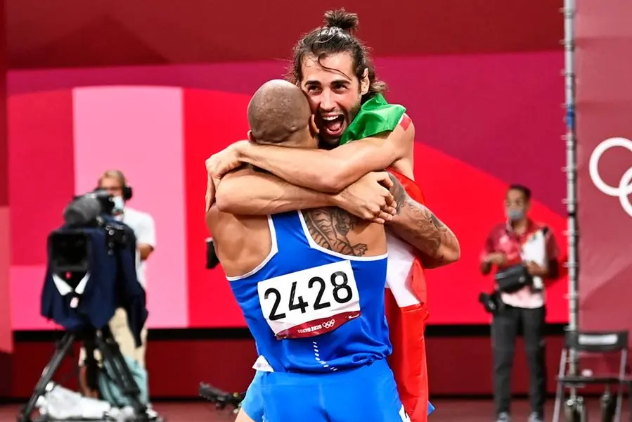 epa09385881 Gold Medalists in Men'sHigh Jump Gianmarco Tamberi of Italy (L) and gold medalist in Men's 100m Marcell Lamont Jacobs of Italy (R) celebrate during the Athletics events of the Tokyo 2020 Olympic Games at the Olympic Stadium in Tokyo, Japan, 01 August 2021. EPA/CHRISTIAN BRUNA