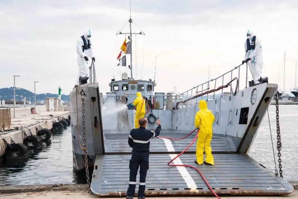 Sanificazioni all'arrivo dei marinai sbarcati dalla portaerei De Gaulle (foto Ansa/Epa)