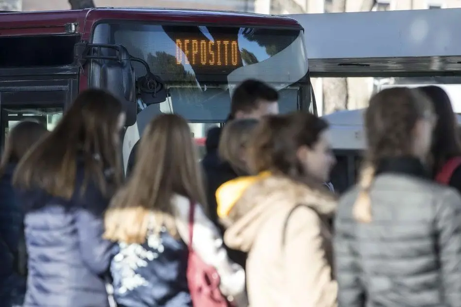 Romani in attesa di un bus (Ansa)
