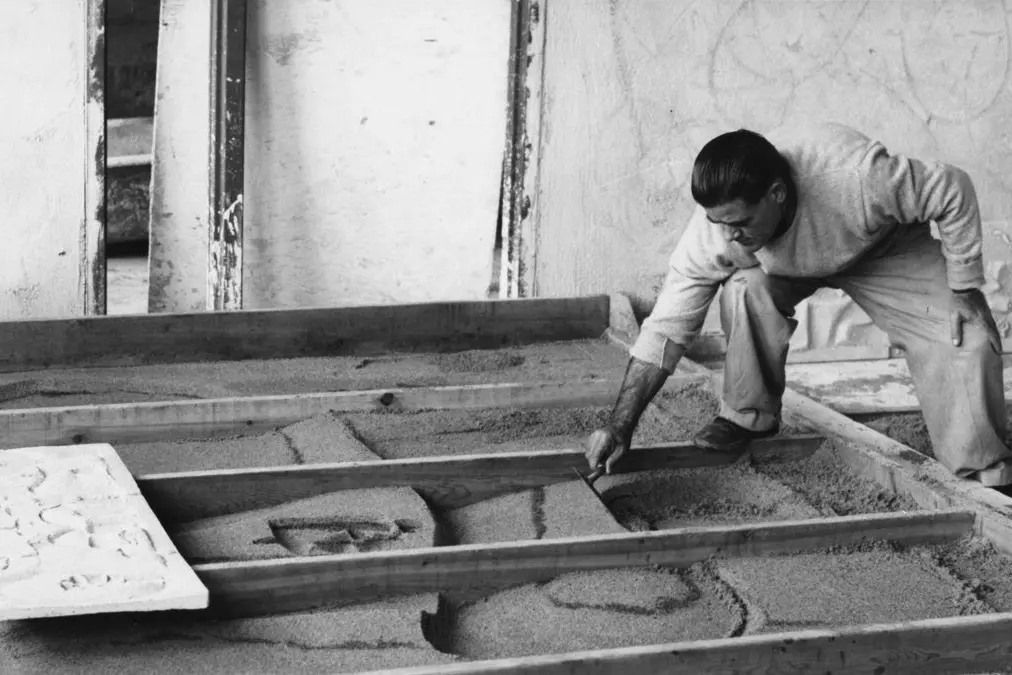 Costantino Nivola (1911-1988) al lavoro su un pannello costruito con la tecnica del sand casting, 1957