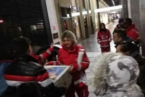 La consegna delle pizze da parte dei volontari della Croce Rossa (foto Facebook)