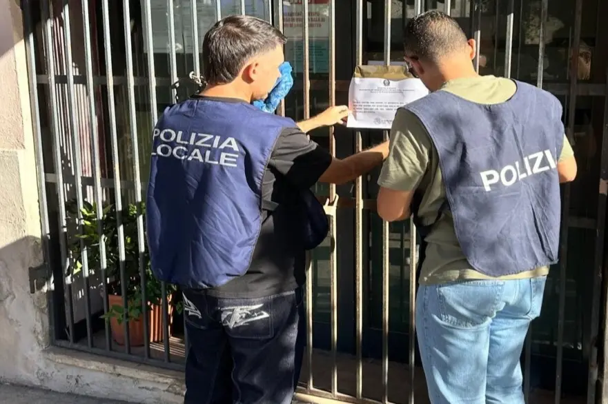 Gli agenti della polizia locale affiggono il provvedimento
